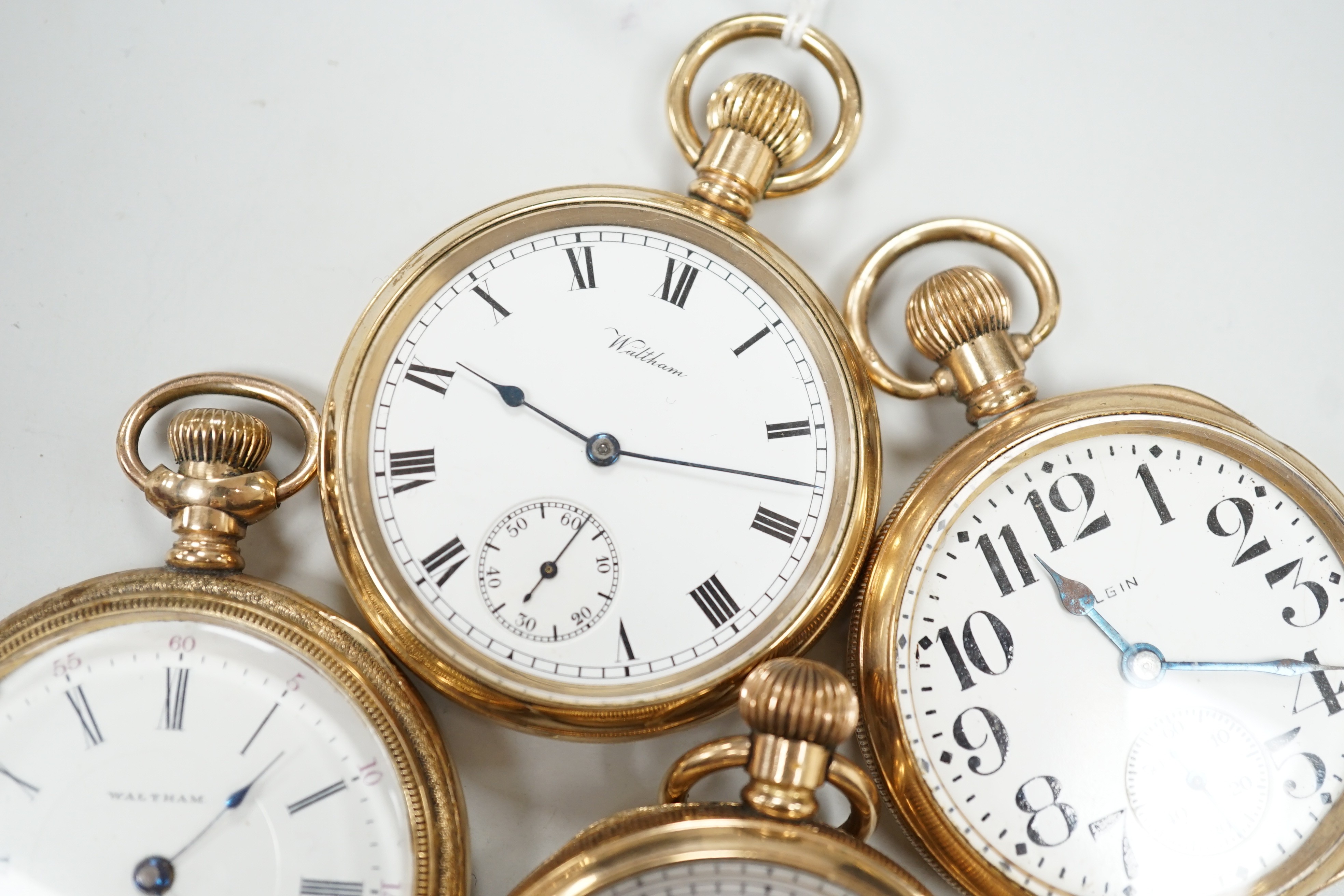 Three assorted gold plated Waltham open faced pocket watches and a similar Elgin pocket watch.